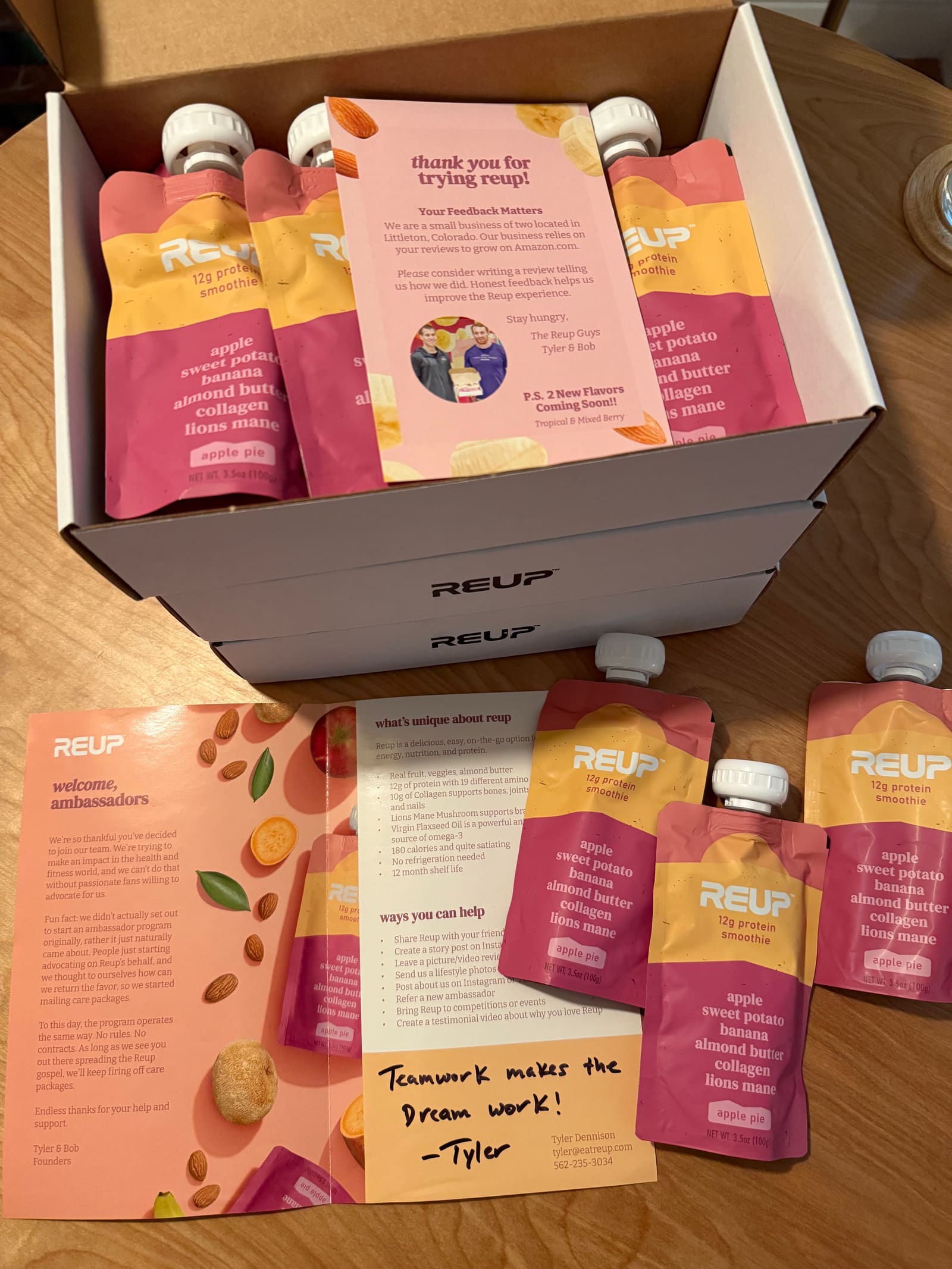 An open Reup box with smoothie pouches, a flyer and a handwritten thank you note